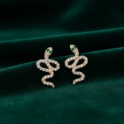 Aretes serpiente con zirconias sobre terciopelo verde